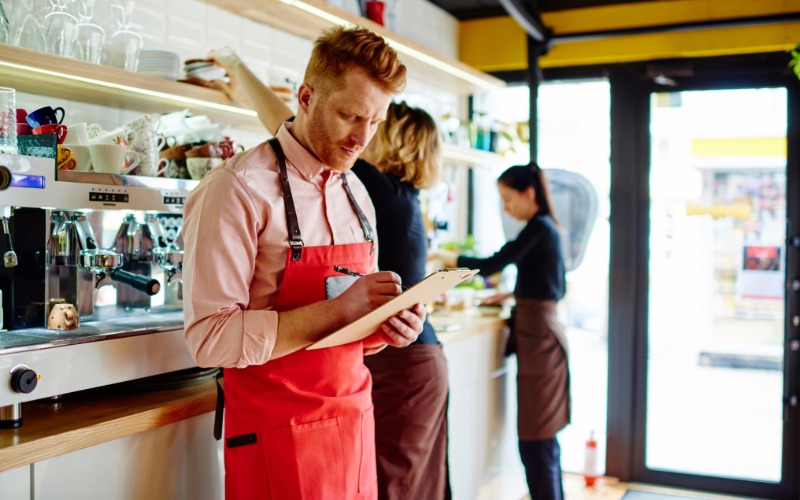 a busy small business owner keeping track of records on a cllipboard