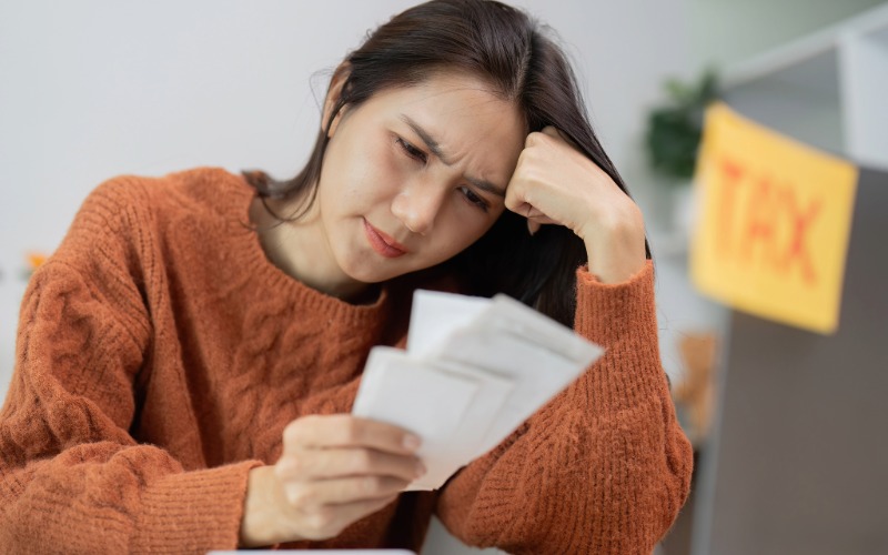 a small business owner looking concerned about financial records and taxes